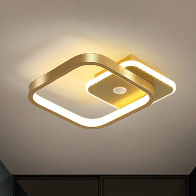 "Moderne LED-taklampe i metall med bevegelsessensor, energieffektiv, i svart og gull, stilrent design."