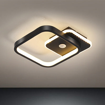 "Moderne LED-taklampe i metall med bevegelsessensor, energieffektiv, i svart og gull, stilrent design."