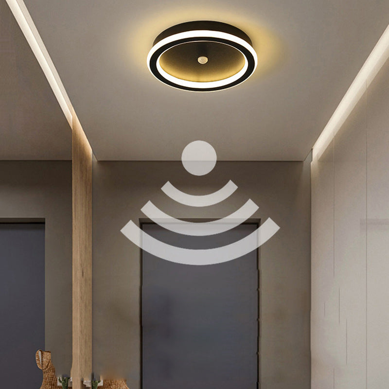 "Moderne LED-taklampe i metall med bevegelsessensor, energieffektiv, i svart og gull, stilrent design."