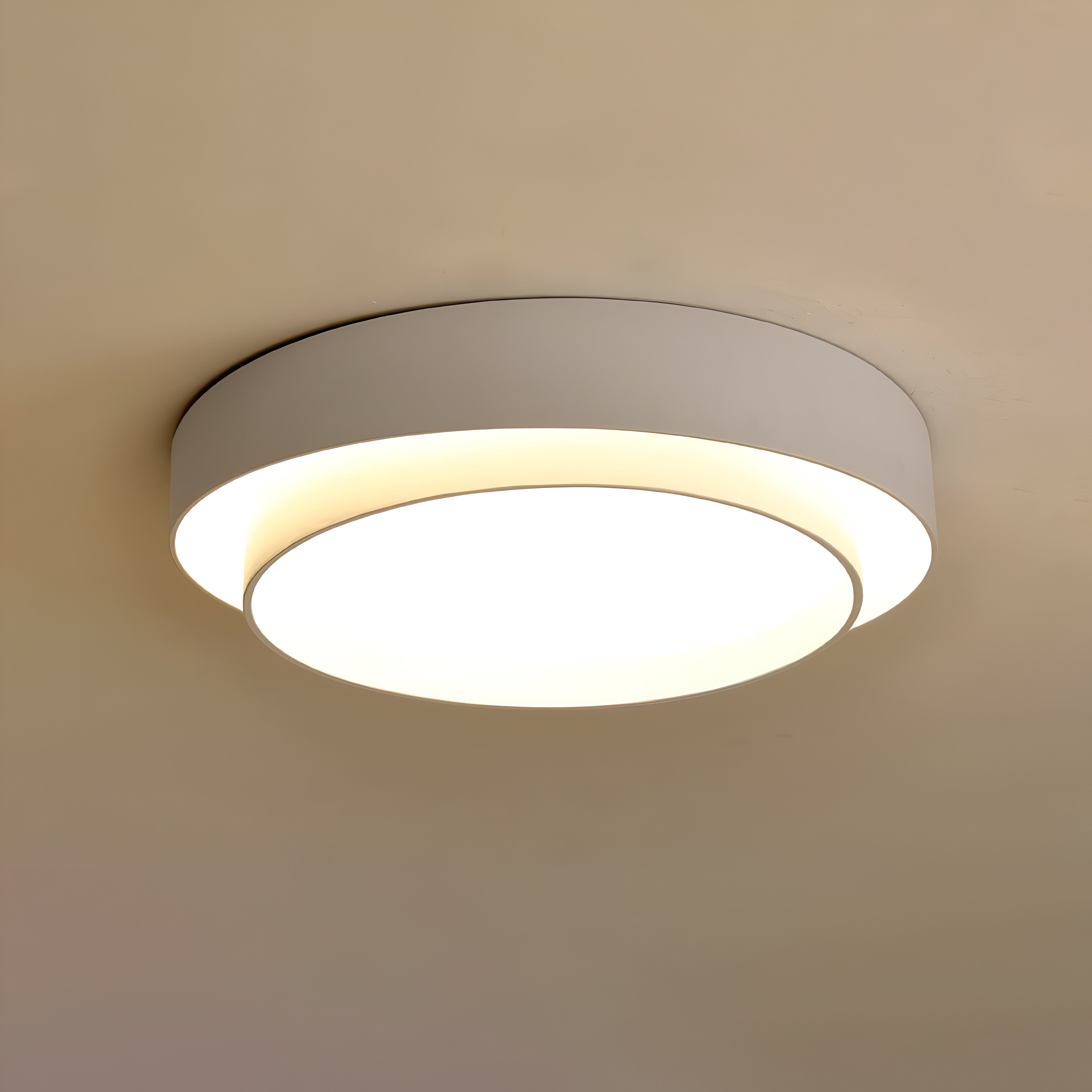 LED taklampe i moderne stue. Fremhever dobbelt sirkulært design og dimbar belysning.