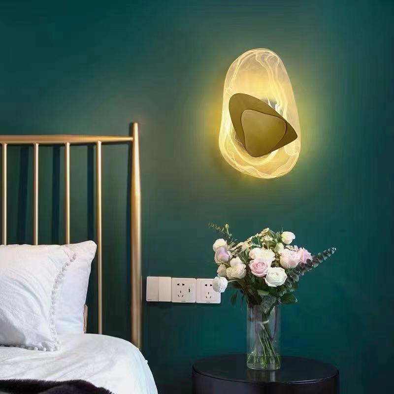 Moderne LED vegglampe i glass, gull og svart. Elegant design med mykt lys for stilfull innredning i stue eller soverom.