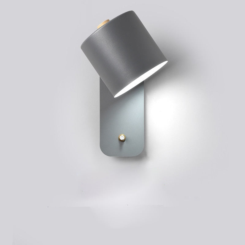 Smal LED vegglampe med bryter montert ved en seng. Optimal soveromslampe for leselys og moderne, dekorativ belysning.