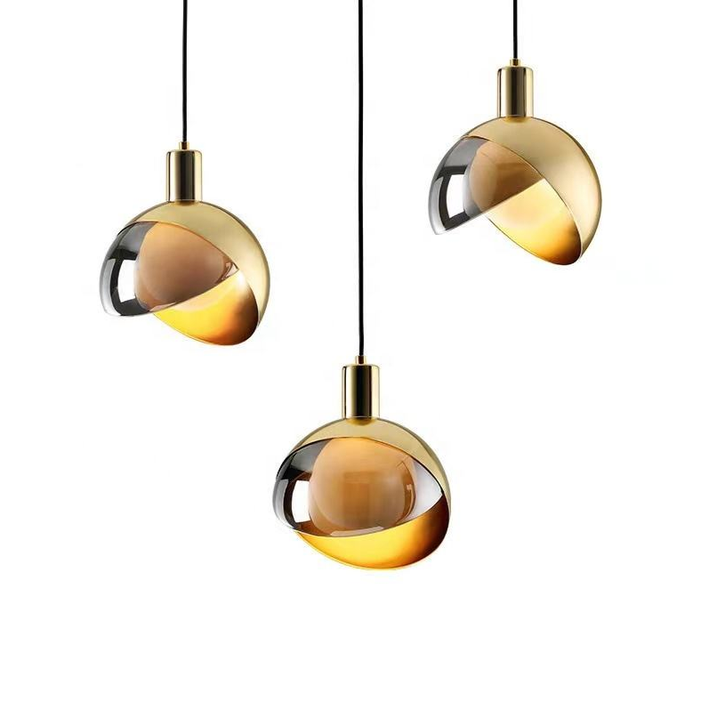 "Moderne pendellampe i gullglass med røykgrå skjerm, elegant nordisk stil, perfekt for stue og spisestue."