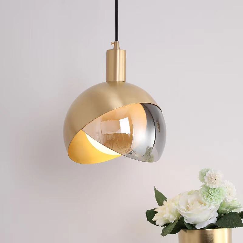 "Moderne pendellampe i gullglass med røykgrå skjerm, elegant nordisk stil, perfekt for stue og spisestue."