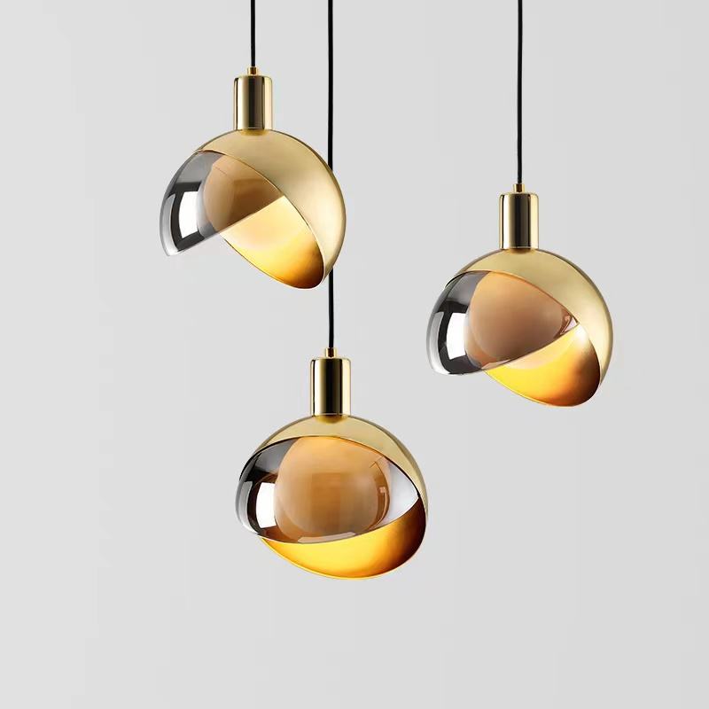 "Moderne pendellampe i gullglass med røykgrå skjerm, elegant nordisk stil, perfekt for stue og spisestue."