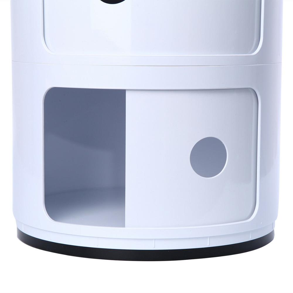 Hvit sylindrisk nattbord med 3 lag plassert ved seng. Smart og moderne oppbevaring for soverommet.