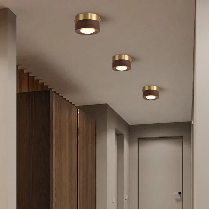 Nærbilde av taklampen, viser elegant valnøttfarget finish og LED-lyskilde. Moderne design.