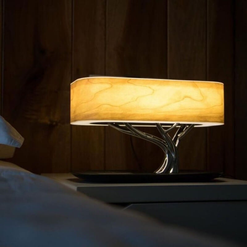 Moderne bordlampe i trestil med LED-belysning og praktisk Bluetooth-høyttaler for musikkavspilling.
