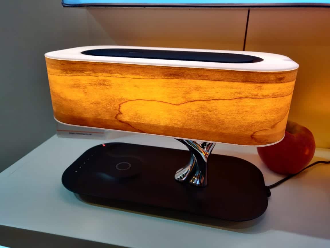 Detalj av trebordlampe som fremhever materialet, LED-lyset og funksjonsknapper for lyd.