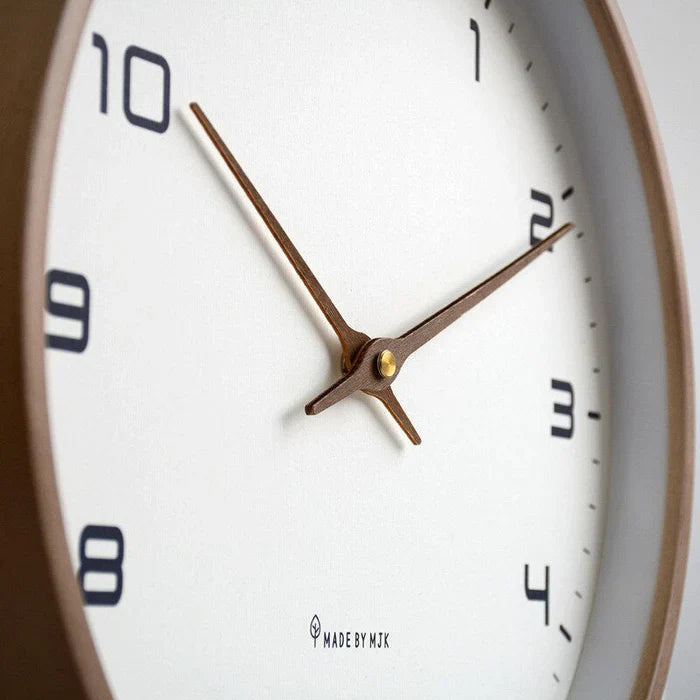 Minimalistisk veggklokke med presis tidtaking. Moderne design i brun og beige, ideell for stilrent innendørs hjem og kontor.