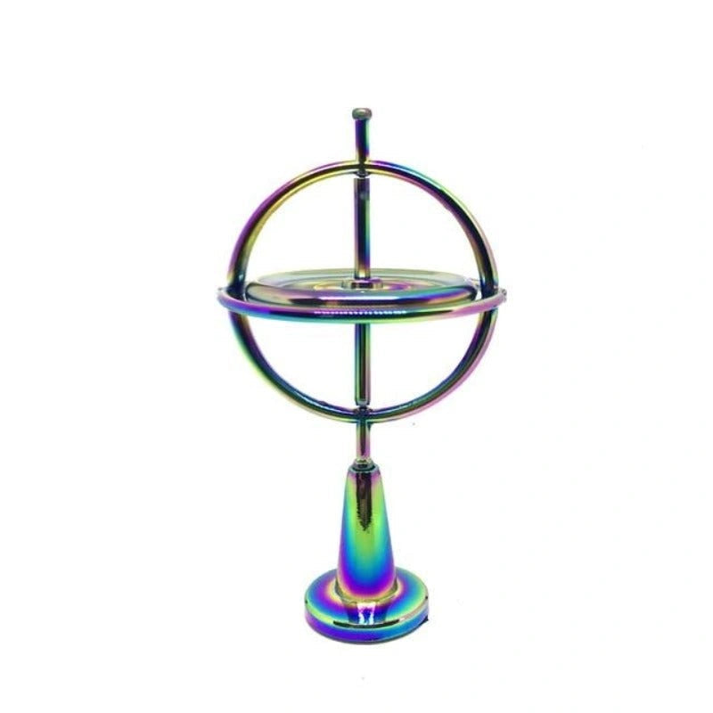 Kinetisk gyroskopisk skrivebordsleke av metall med speilblank overflate som reflekterer lys, kontor og fokus.