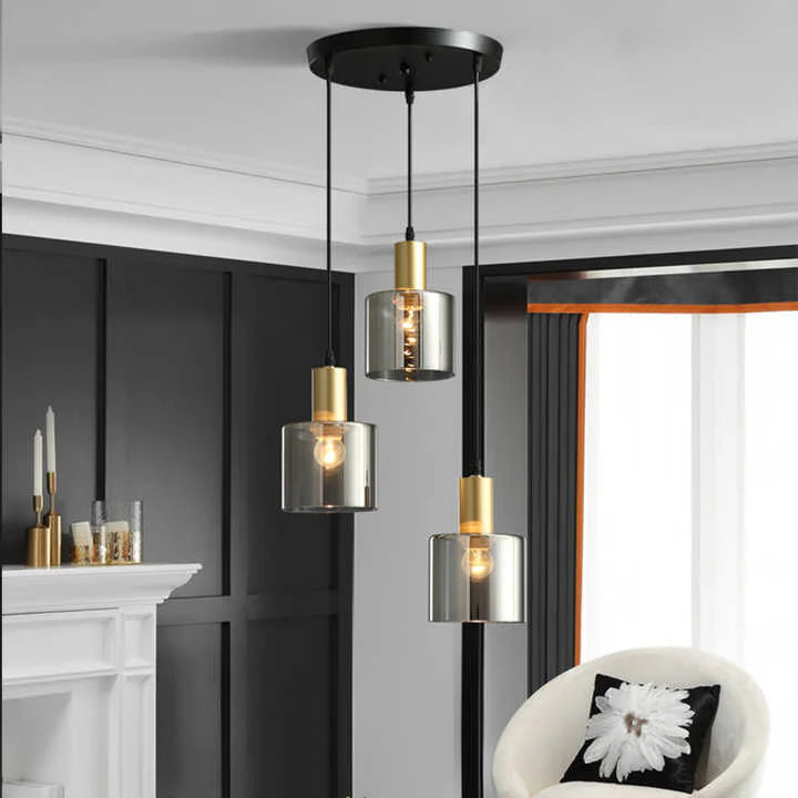 "Pendellampe i svart med gylne detaljer, røykfarget glass; justerbart lys for moderne stil og luksuriøs atmosfære."