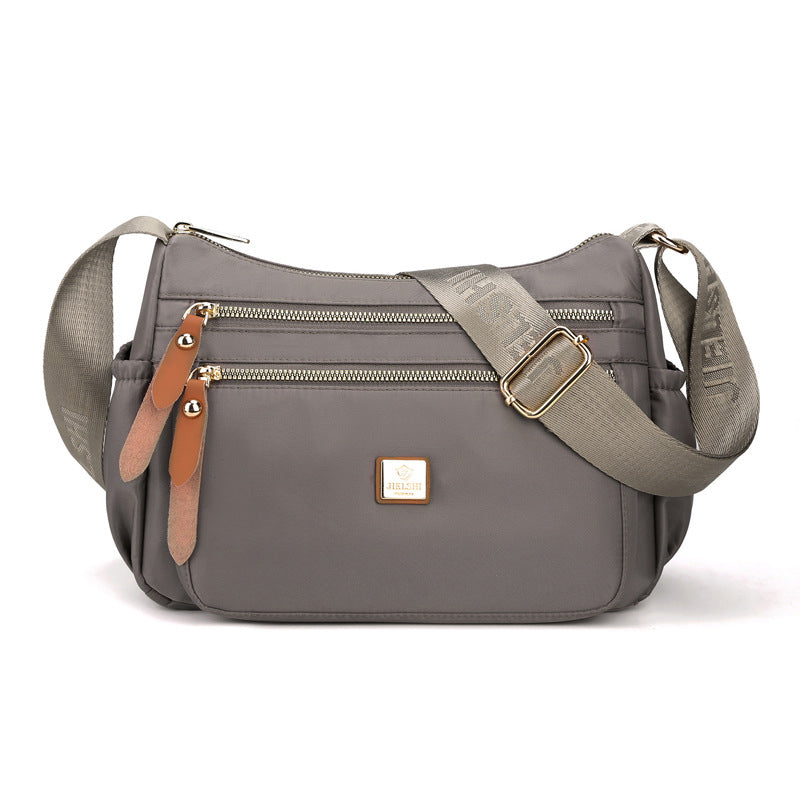 Praktisk skulderveske med flere rom i lett, slitesterkt nylon, ideell for daglig bruk og reiser, i elegant design.