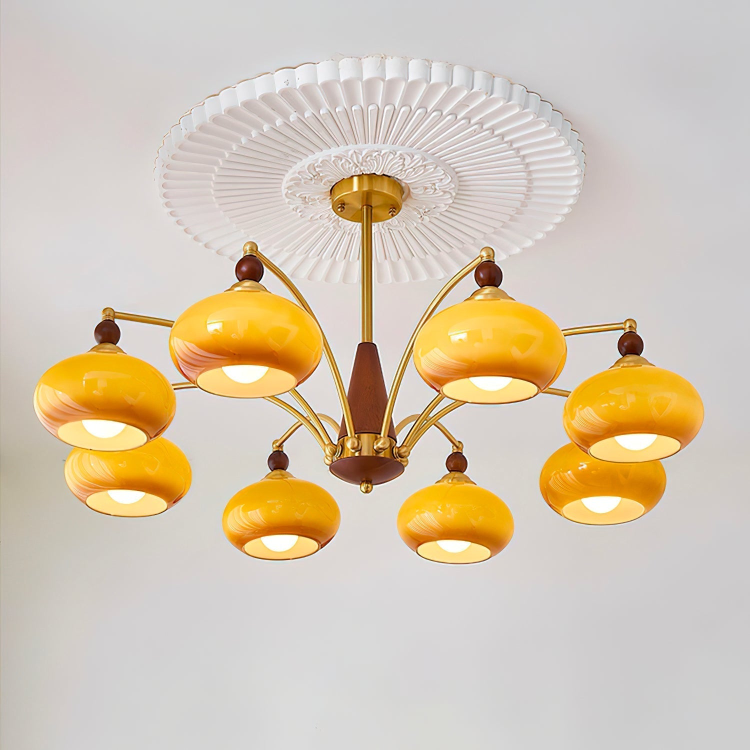 "Retro lysekrone med gyllengule skjermer og klassisk design, laget av tre og messing, gir varmt lys til spisestue."