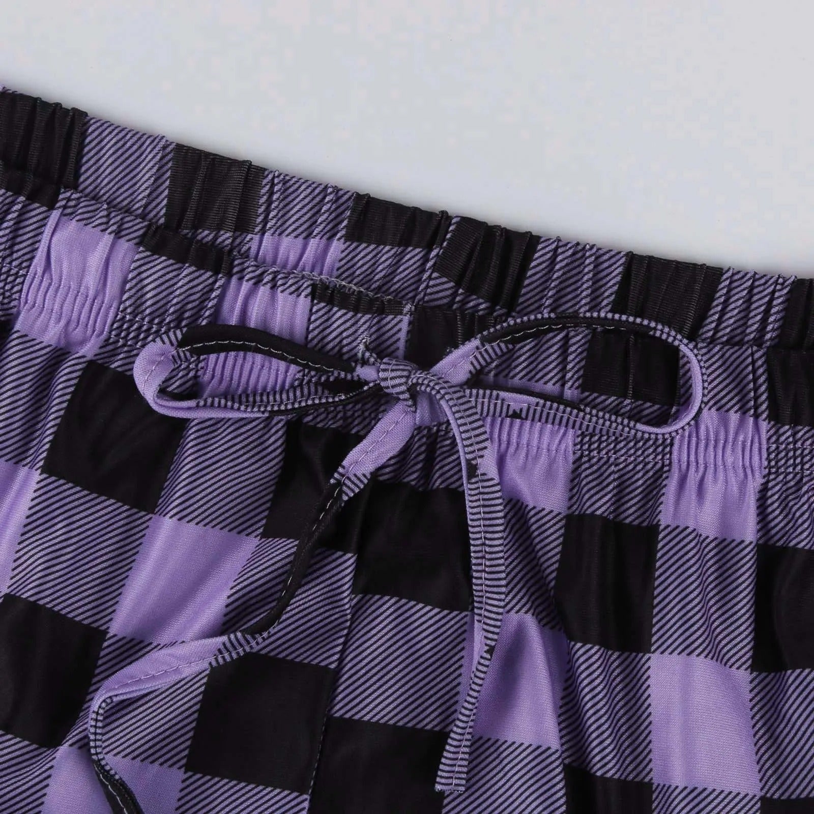 De rutete pyjamasbuksene vises sammen med en kaffekopp, symboliserer koselig morgenstund for kvinner.