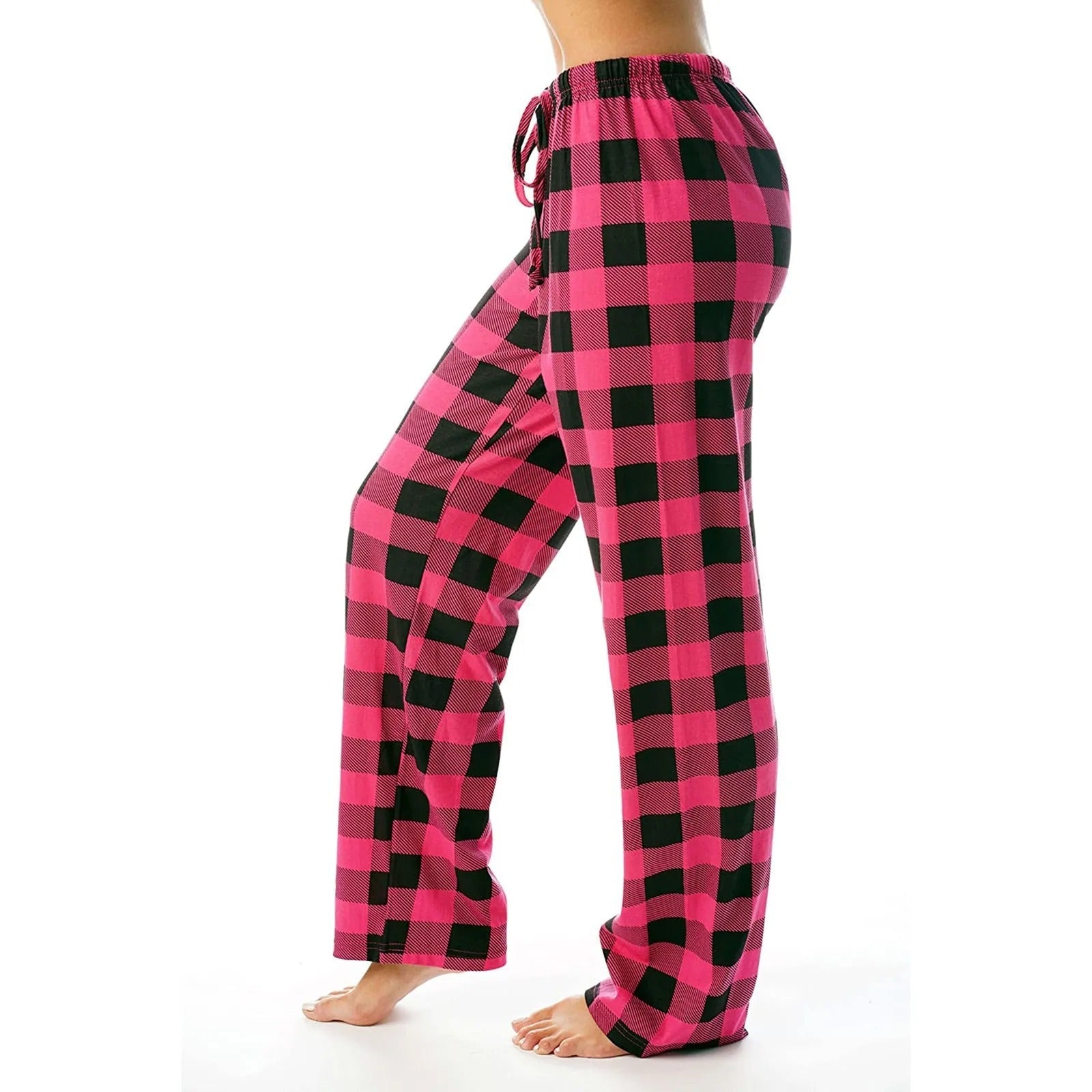 En kvinne sitter komfortabelt i sine rutete pyjamasbukser, som er ideelle som varm og stilig vinterpyjamas.
