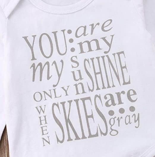 Detalj av trykket på bomullsromper for baby jente, mykt og hudvennlig.