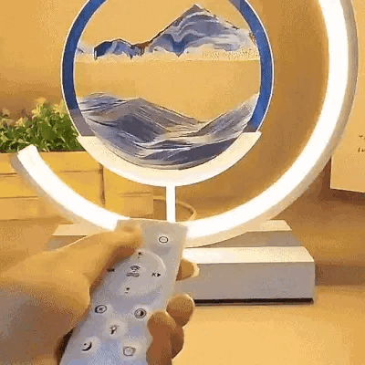 "Sandlampe med dimbart LED-lys og flytende sand i bevegelse, skaper ro og eleganse i moderne bordlampe-design."