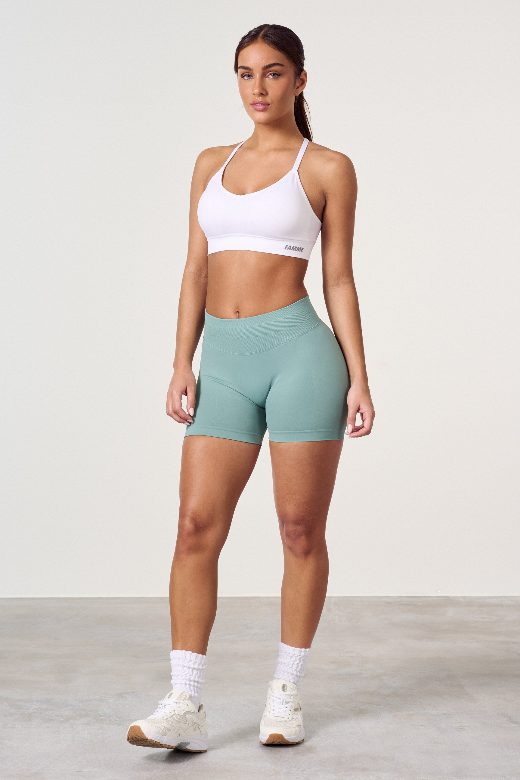 "Sømløse treningsshorts med scrunch-effekt for kurver, sort, sett forfra. Komfortabel med mid waist og 4-veis stretch."