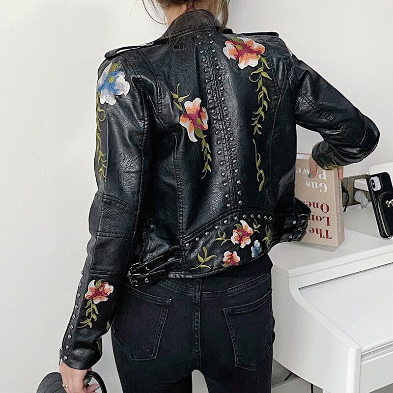 Nærbilde av krage og skulder på dame skinnjakke med fint blomsterbroderi. Elegant design.