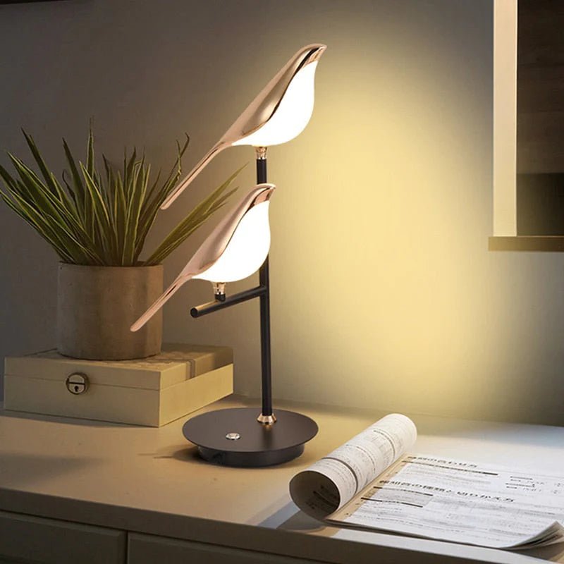 "Stilfull LED-bordlampe i gullfugldesign, elegant og moderne. Perfekt belysning for stue, soverom eller kontor."