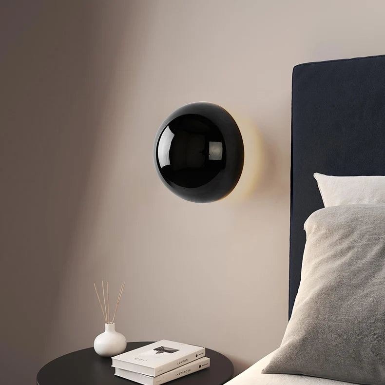 "Stilfull vegglampe med rund silhuett, gull finish og solformørkelseseffekt. Perfekt for moderne og middelalderlig interiør."