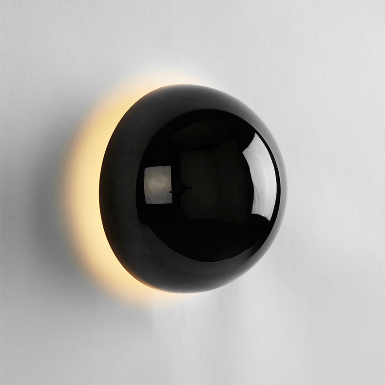 "Stilfull vegglampe med rund silhuett, gull finish og solformørkelseseffekt. Perfekt for moderne og middelalderlig interiør."