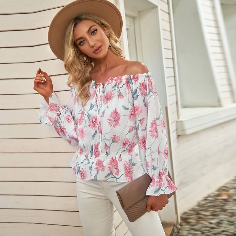 Lett blomstret off-shoulder bluse for dame, med delikate volanger. En mønstret topp for sommer.