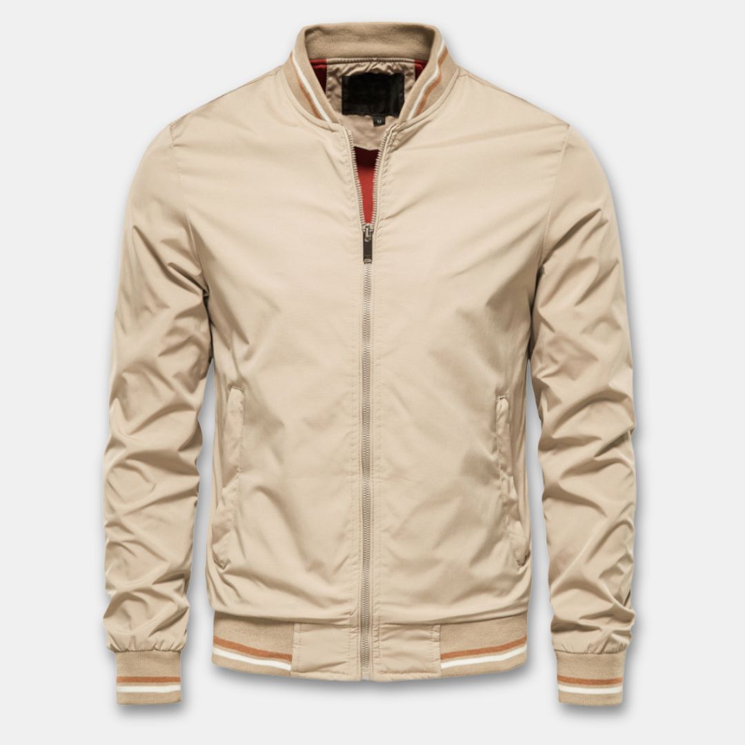 Mann iført trendy lettvektig bomberjakke i grå, kombinert med jeans. Allsidig herrejakke for en avslappet stil.