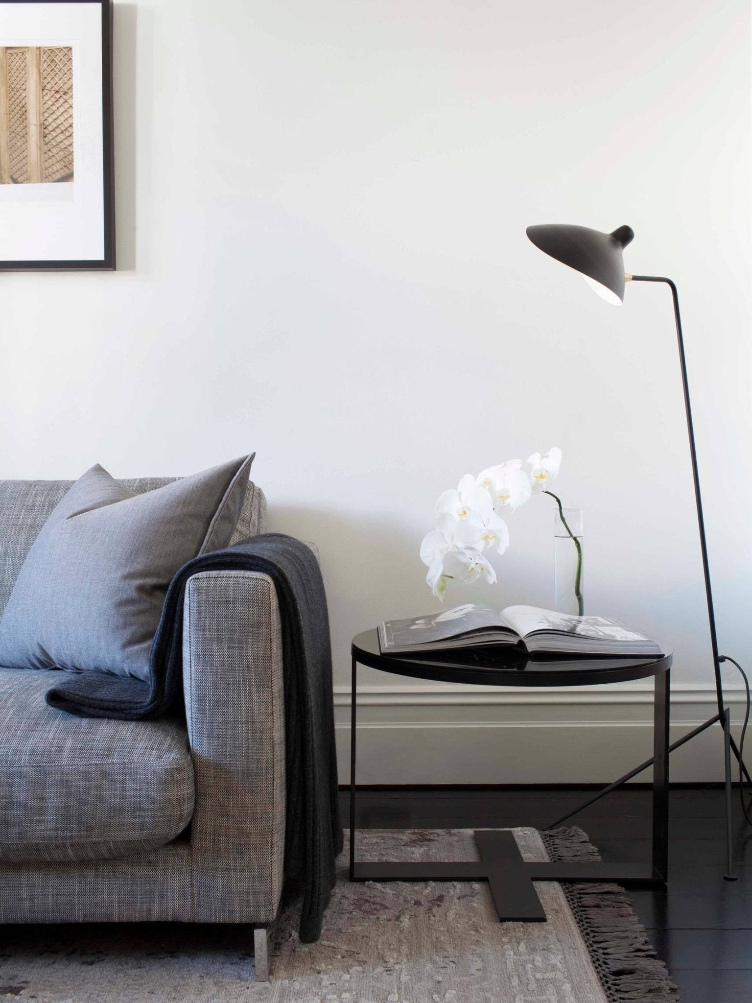 "Stilren svart gulvlampe med skulpturelle linjer og tre justerbare armer, ideell for moderne interiørdesign."