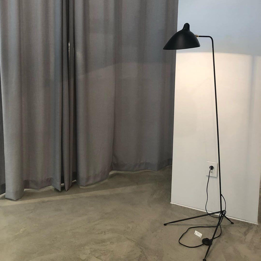 "Stilren svart gulvlampe med skulpturelle linjer og tre justerbare armer, ideell for moderne interiørdesign."