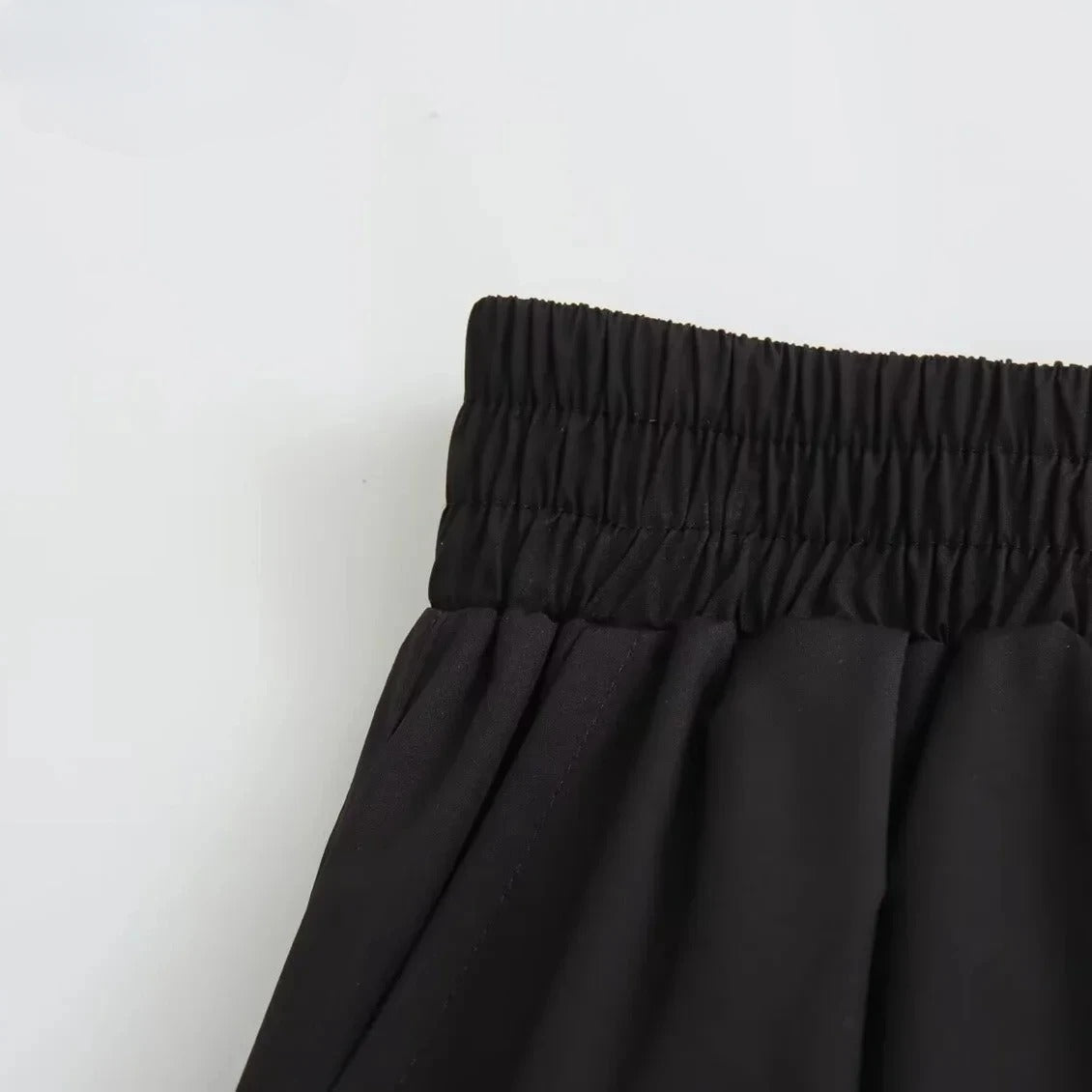Tidløst svart plissert dameskjørt med høy midje, ideelt for en elegant vårgarderobe.