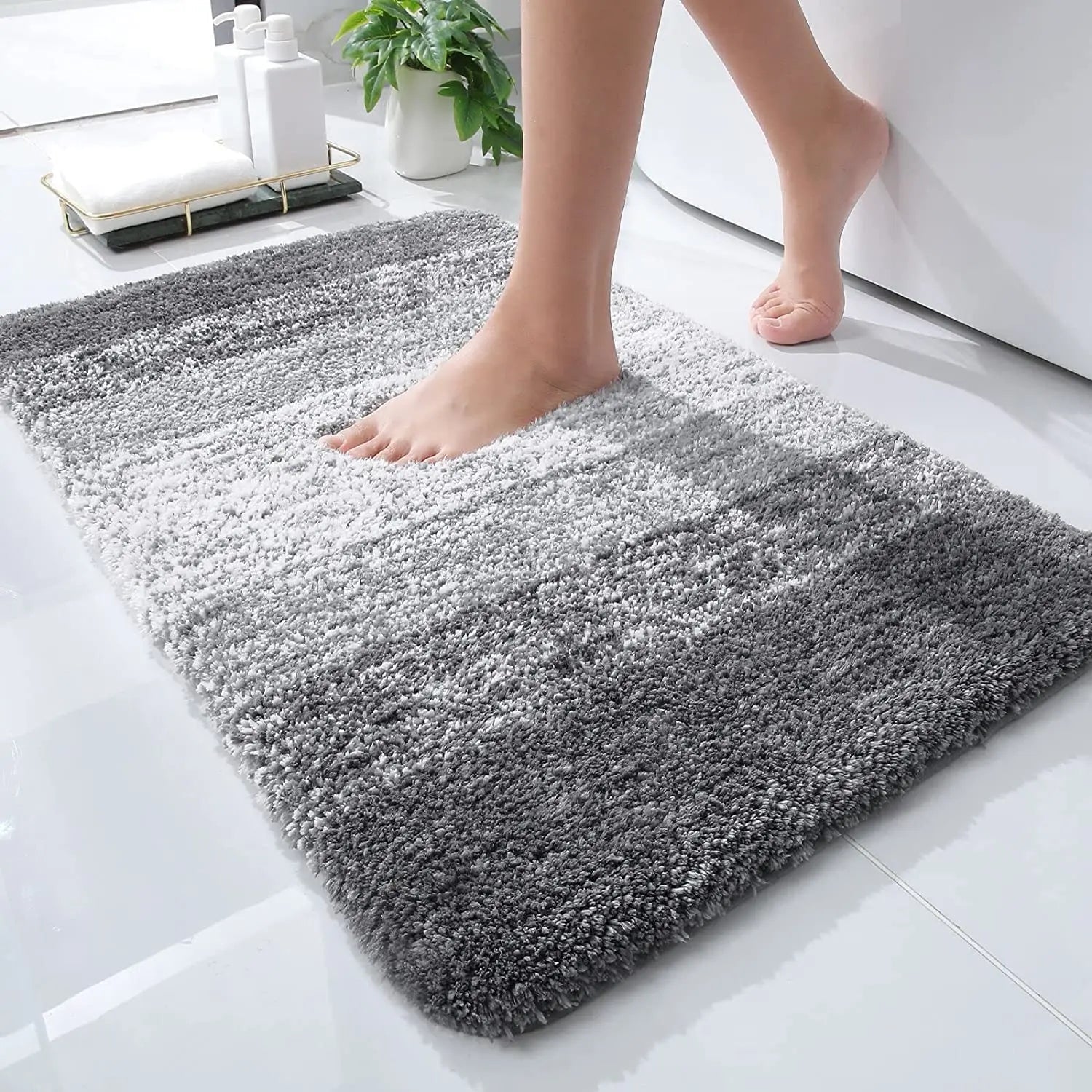 Nærbilde av grå mikrofiber badematte med høy luv, viser myk tekstur og absorberende egenskaper.