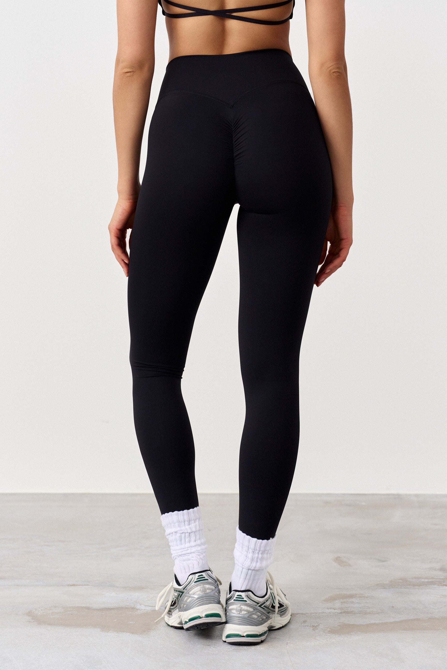 "Svart scrunch-effekt leggings med høyt liv for optimal passform og komfort under trening, sett på modell."