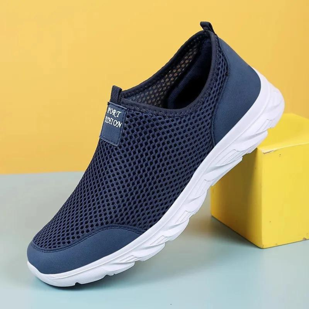 "Svart slip-on herresko med pustende netting og hvit såle. Komfortabel og slitesterk for daglig bruk."