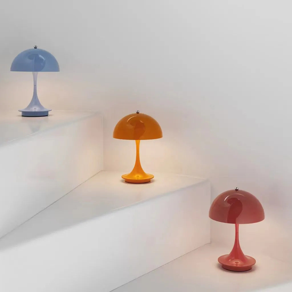 "Trådløs bordlampe med justerbar lysstyrke og elegant design, laget av metall og glass, tilgjengelig i hvit og oransje."
