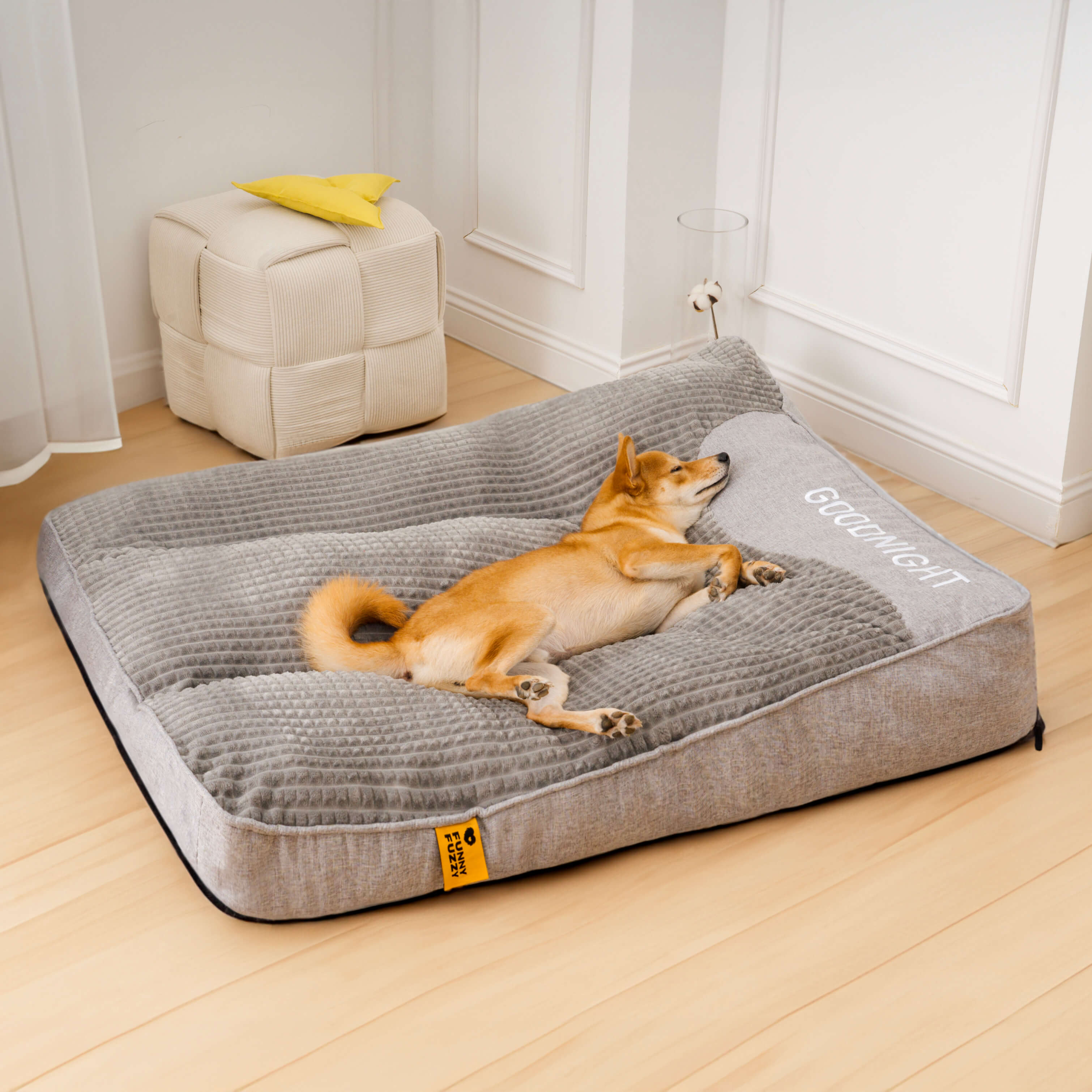 "Tykk ripebeskyttende hundeseng, myk, slitesterk med ryggstøtte, beige farge, i rom med stilfull innredning."