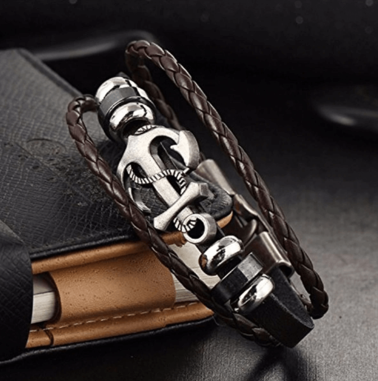 Nærbilde av unisex ankerarmbånd med detaljert sølvanker og flettet brunt skinn, tidløs maritim look.