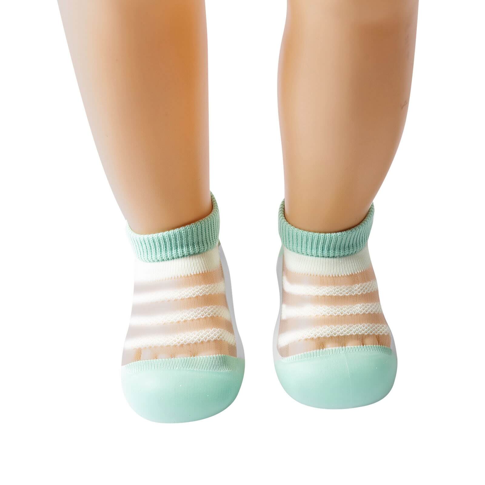 Nærbilde av slitesterk, sklisikker såle på grå unisex babysko, pustende for første trinn