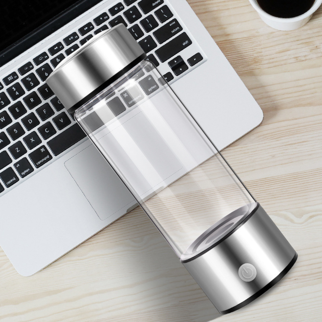 Bildet viser en unisex vannflaske med hydrogen generator, laget av borosilikatglass, med en USB-ladeport synlig.