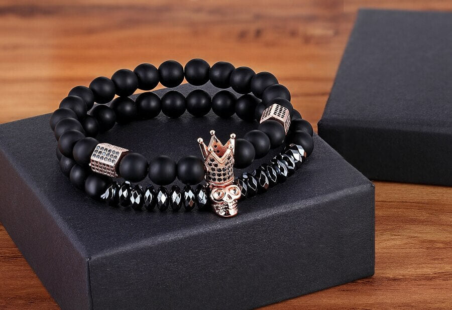Unisex armbånd med glatte onyxperler, krone og hodeskalle anheng. Steinarmbånd som gir stil og mening.