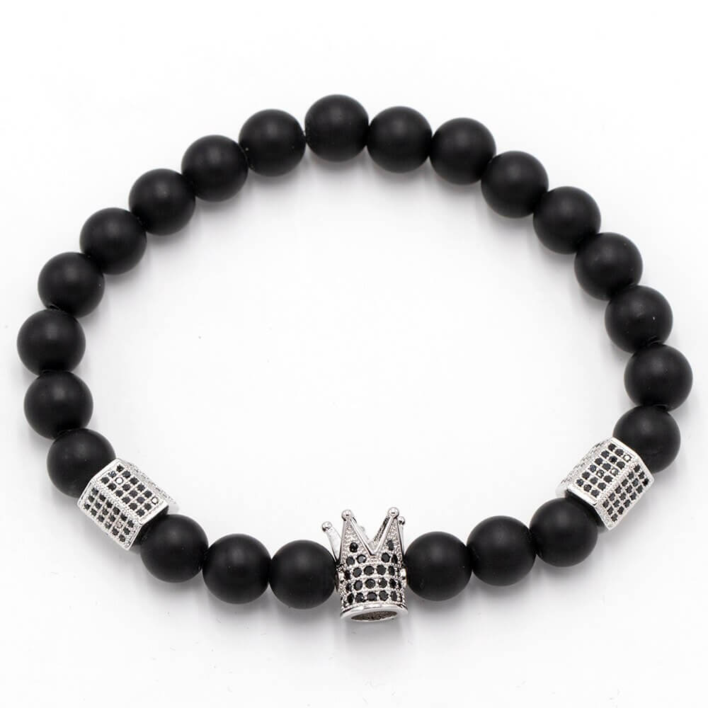 Sort matt onyx unisex perlearmbånd med glansfulle gullfargede krone og hodeskalle sjarmer. Trendy stil.