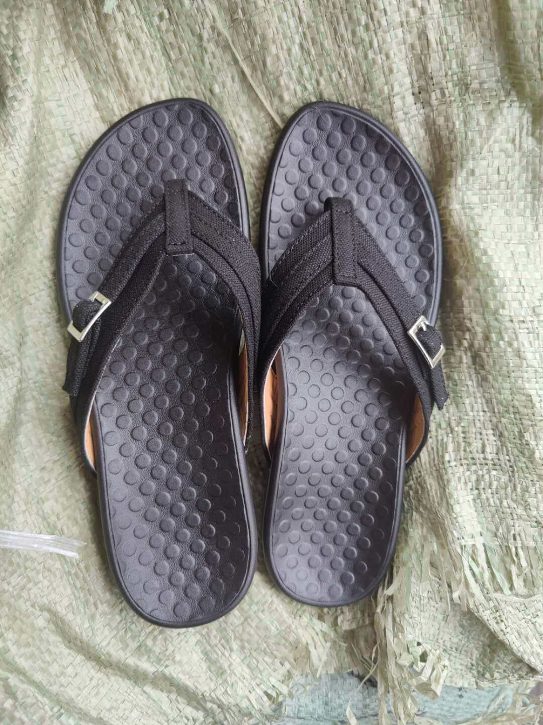 Fot i ortopedisk flip-flop, nærbilde av ergonomisk såle for fotstøtte.