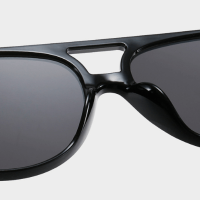 Lifestyle bilde av person som bruker unisex retro aviator solbriller, mot solen, med UV400.