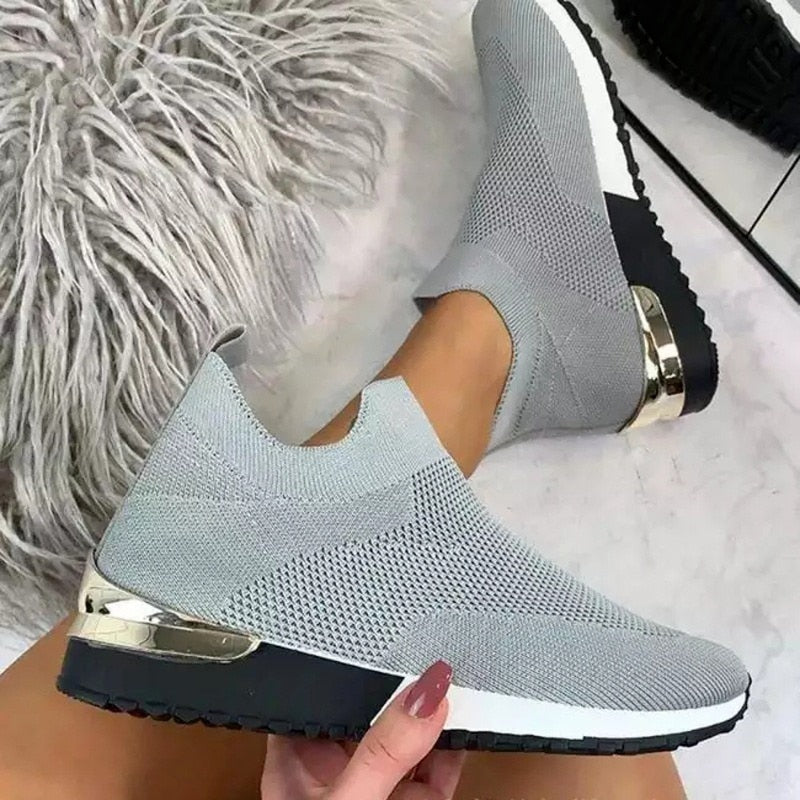 Hvite unisex slip-on sko med pustende mesh og fotstøtte, perfekt for fritidsbruk og hverdagskomfort.