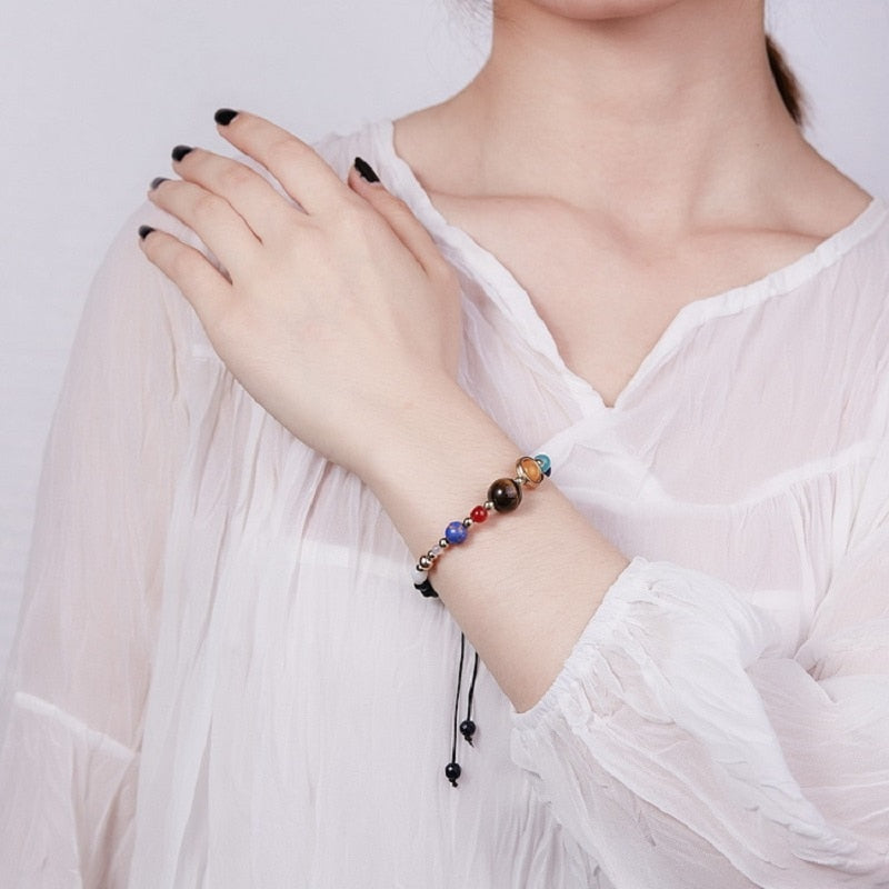Detaljert armbånd inspirert av solsystemet, med unike natursteiner for hver planet. Åndelig og energifullt.