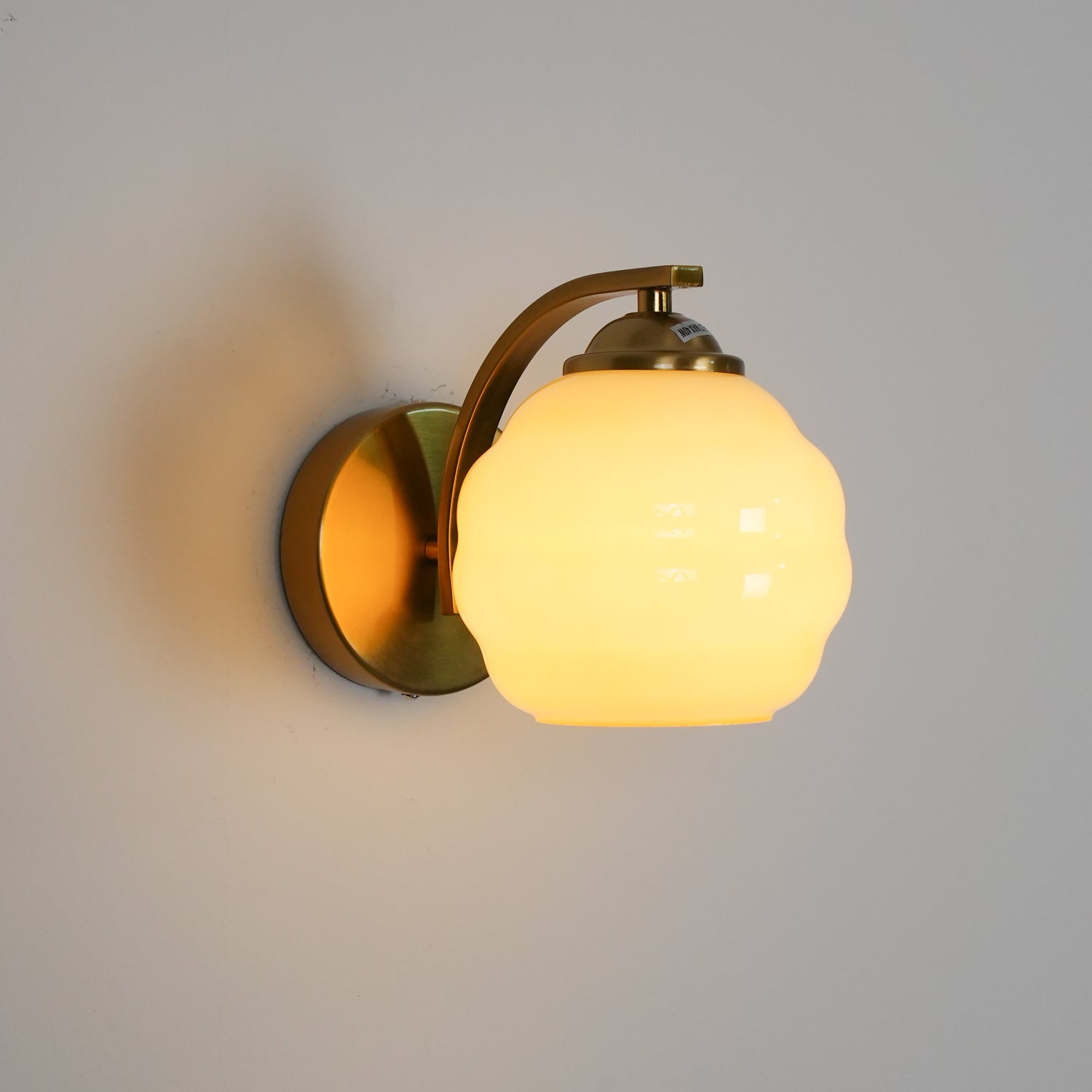 "Vintage Art Deco vegglampe i hvitt glass, kurvede konturer, tilgjengelig i gull og krom, elegant for moderne interiør."