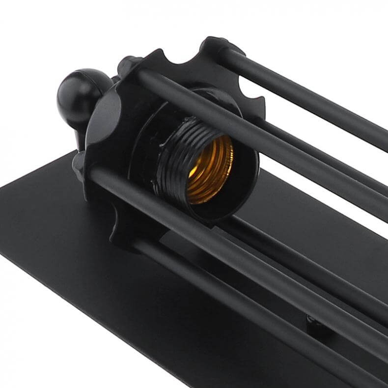 Nærbilde av detaljrik industriell vegglampe, svart metallbur og vintage utseende