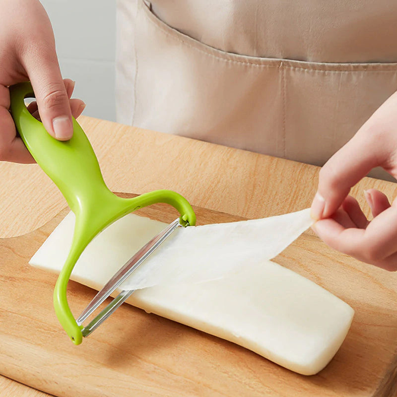 Y-skreller med bredt rustfritt stålblad og ergonomisk plastgrep for enkel skrelling av frukt og grønnsaker.